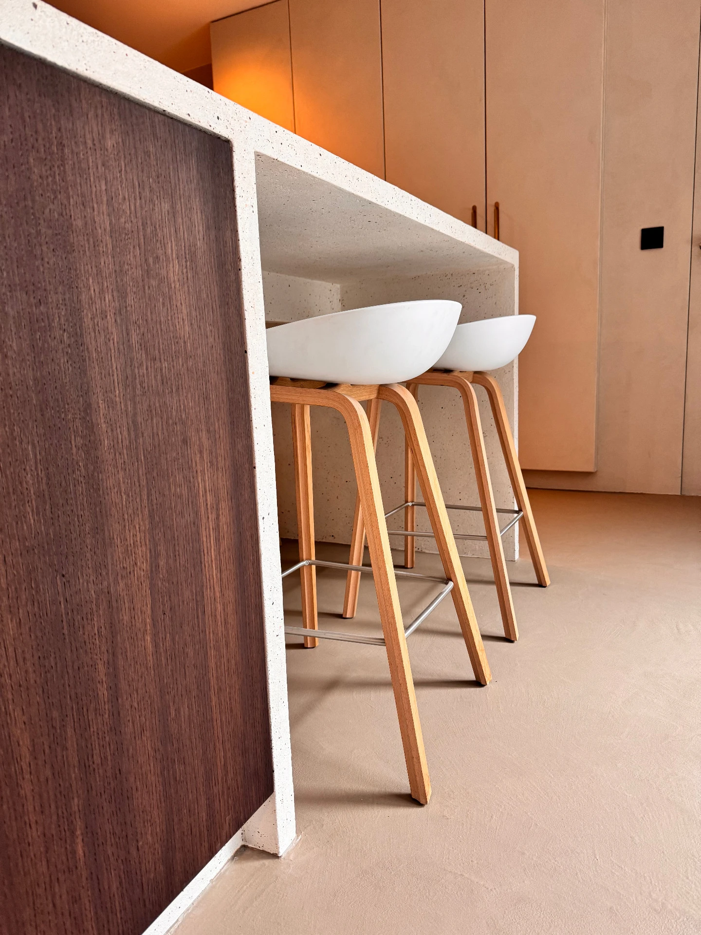 modern interieur met witte barkrukken en natuursteen bar ontworpen door interieurarchitect frédéric lammertyn