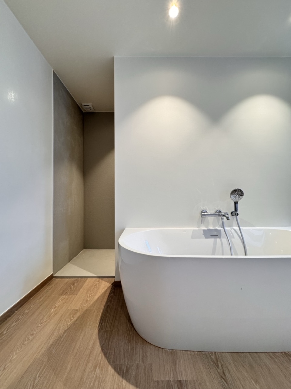 minimalistisch interieur met vrijstaand bad en inloopdouche door interieurarchitect Frédéric Lammertyn