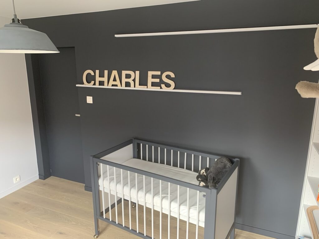 minimalistisch babykamer interieur met grijze muur en ledikant ontworpen door interieurarchitect Frédéric Lammertyn